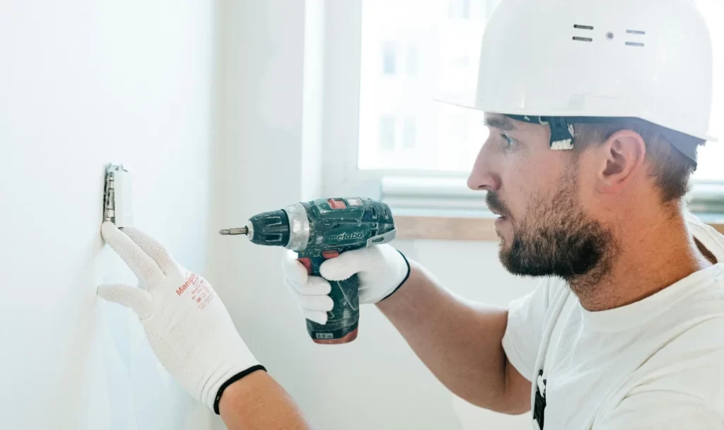 Électricien installant des câbles lors d'une rénovation au Québec.